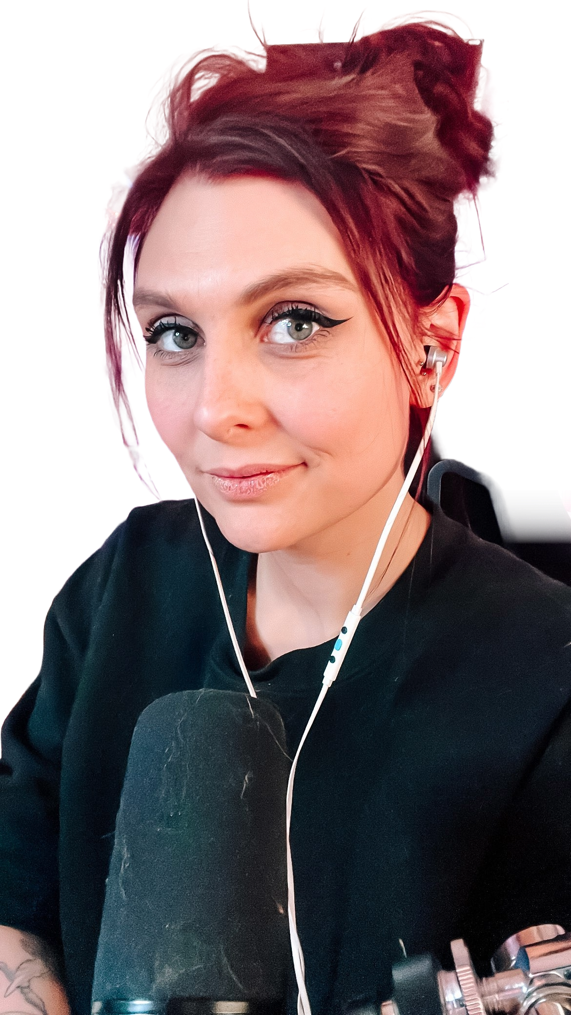 Frau mit hochgesteckten, roten Haaren und Kopfhörern spricht in ein Mikrofon, vor einer Streaming-Ausrüstung, bekannt als Yushina.